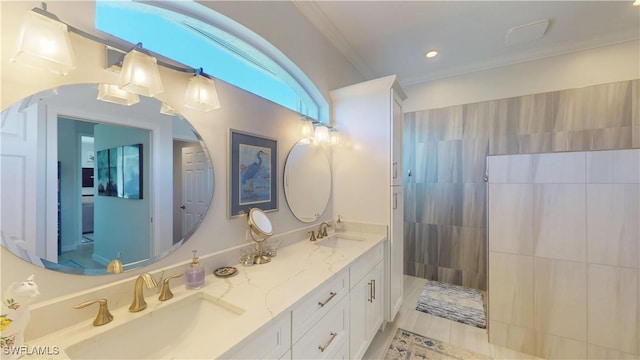 full bathroom featuring ornamental molding, double vanity, a sink, and a walk in shower