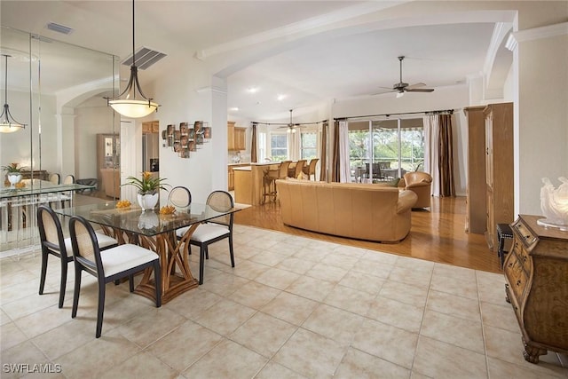 dining area featuring ornamental molding, ceiling fan, arched walkways, light tile patterned flooring, and visible vents