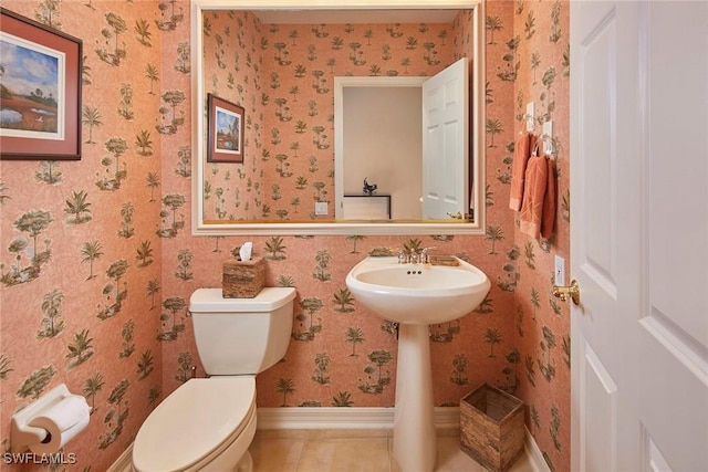 bathroom featuring baseboards, wallpapered walls, toilet, and tile patterned flooring