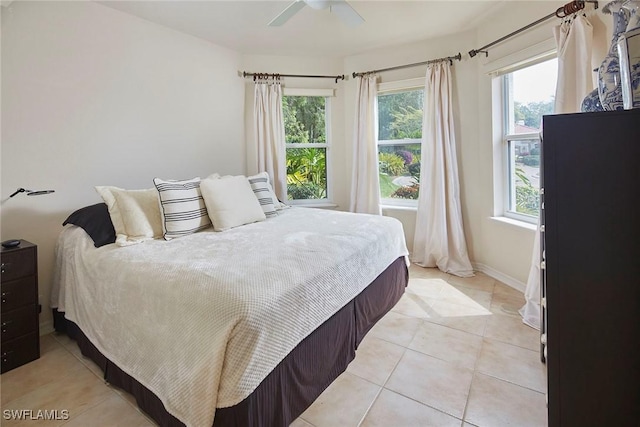 bedroom with baseboards, light tile patterned flooring, and ceiling fan