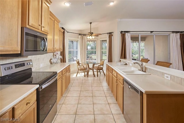 kitchen featuring light tile patterned floors, stainless steel appliances, light countertops, backsplash, and a sink