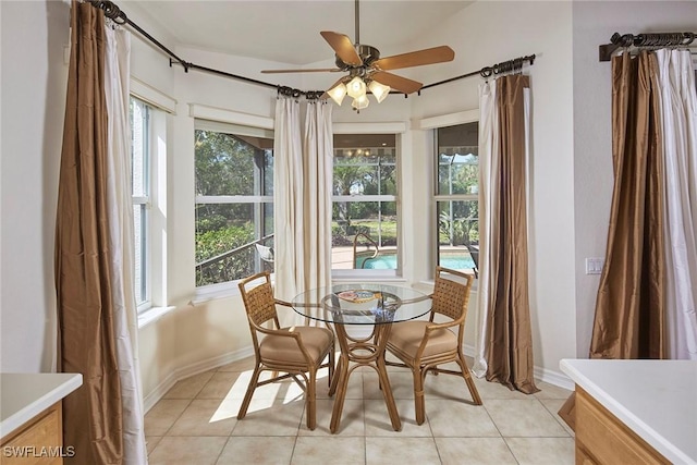 dining space featuring ceiling fan, light tile patterned floors, and baseboards