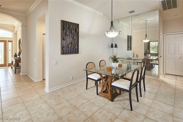 dining area featuring plenty of natural light, light tile patterned floors, arched walkways, and visible vents