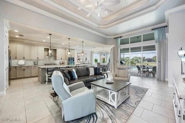 living room featuring ceiling fan, light tile patterned floors, crown molding, and a raised ceiling