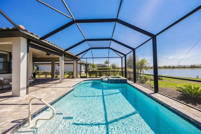 view of pool with glass enclosure, a pool with connected hot tub, a patio area, and a water view