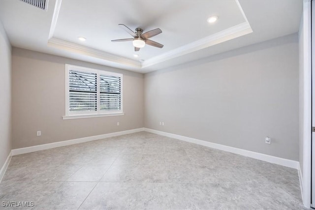 empty room with crown molding, a raised ceiling, visible vents, ceiling fan, and baseboards