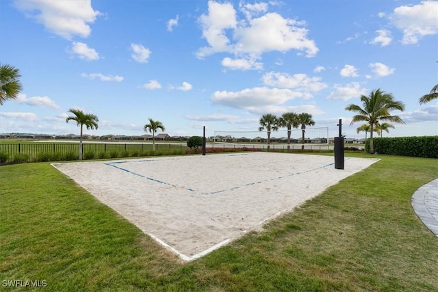 view of property's community featuring volleyball court, a lawn, and fence