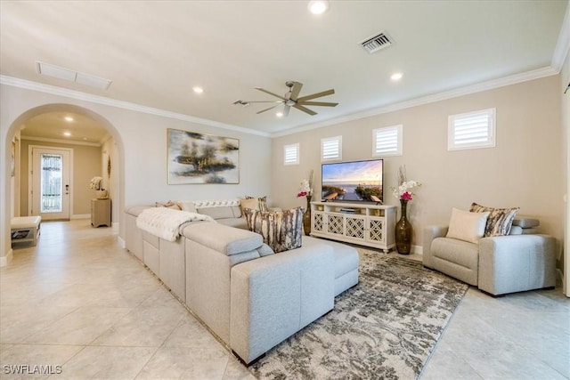 living room with baseboards, visible vents, arched walkways, and crown molding