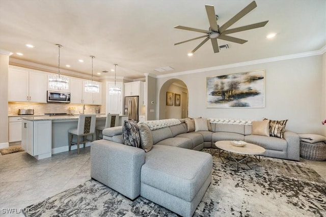 living area featuring recessed lighting, visible vents, arched walkways, and ornamental molding