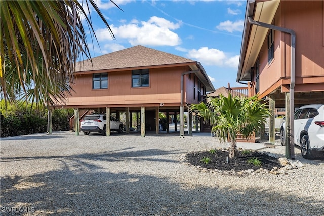 view of car parking with a carport and gravel driveway