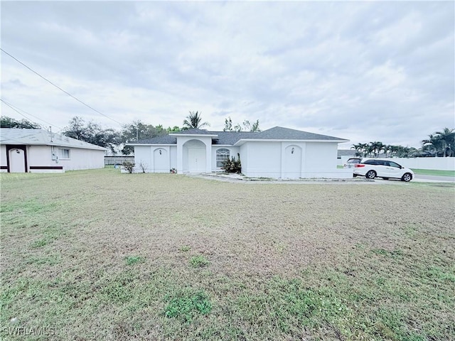 view of front of house featuring a front yard and stucco siding