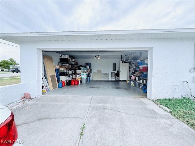 garage with electric panel and concrete driveway