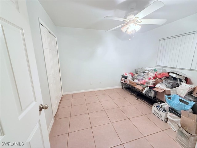 bedroom with a closet, baseboards, a ceiling fan, and light tile patterned flooring