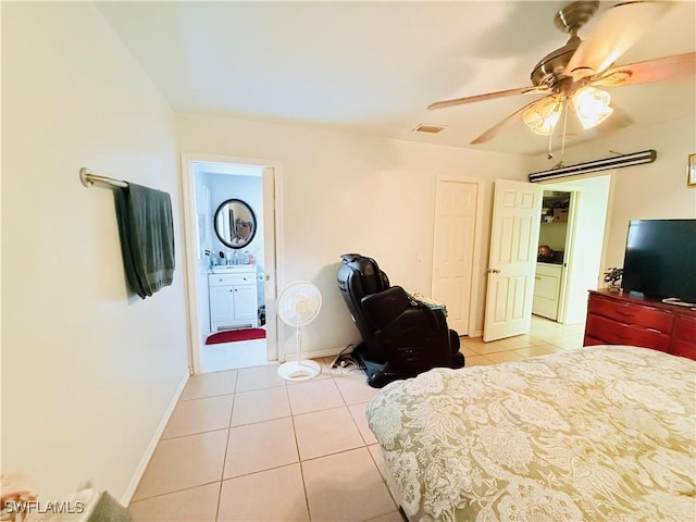 bedroom with light tile patterned floors, ensuite bathroom, a ceiling fan, visible vents, and baseboards