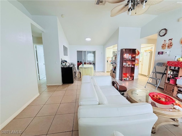 living room featuring lofted ceiling, light tile patterned flooring, visible vents, a ceiling fan, and baseboards