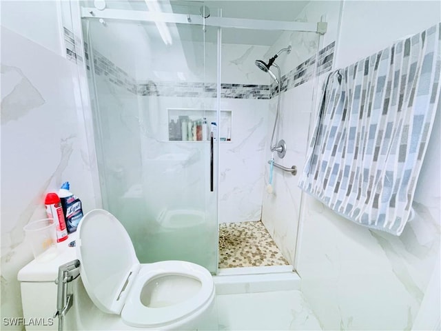 bathroom with a shower stall and toilet