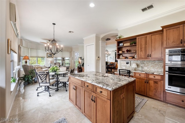 kitchen with arched walkways, open shelves, visible vents, hanging light fixtures, and a chandelier