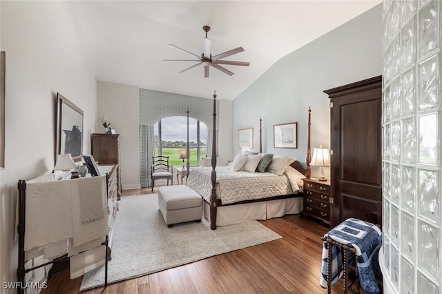 bedroom featuring arched walkways, a ceiling fan, vaulted ceiling, and wood finished floors