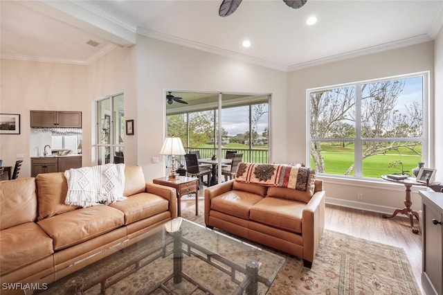 living area with crown molding, recessed lighting, ceiling fan, light wood-type flooring, and baseboards