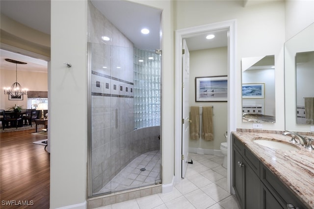 full bath featuring toilet, a shower stall, a notable chandelier, and vanity