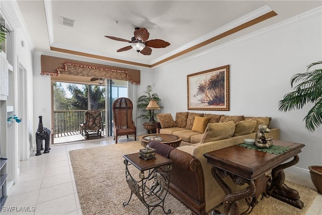 living area featuring light tile patterned floors, a ceiling fan, visible vents, crown molding, and a raised ceiling