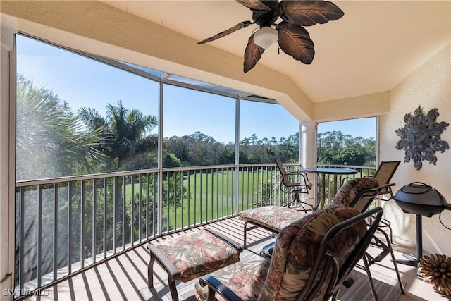 sunroom with ceiling fan and vaulted ceiling