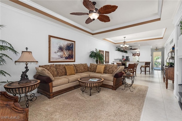 living room featuring light tile patterned flooring, ceiling fan with notable chandelier, a raised ceiling, and ornamental molding