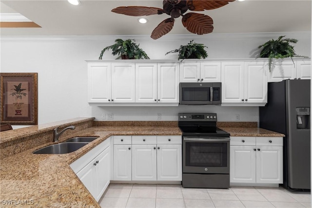 kitchen with a sink, stainless steel appliances, ornamental molding, and white cabinetry