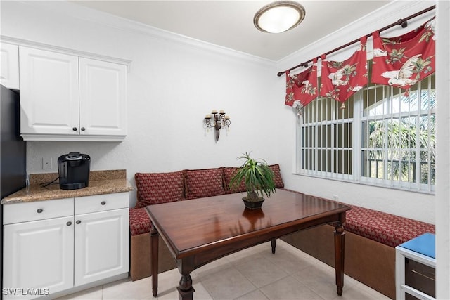 dining area featuring light tile patterned flooring and crown molding