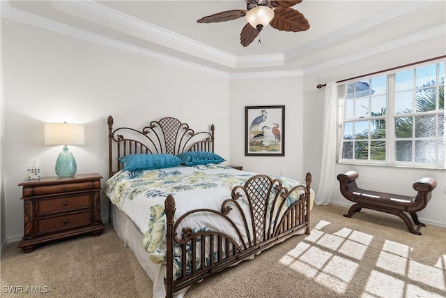 carpeted bedroom featuring baseboards, crown molding, and ceiling fan