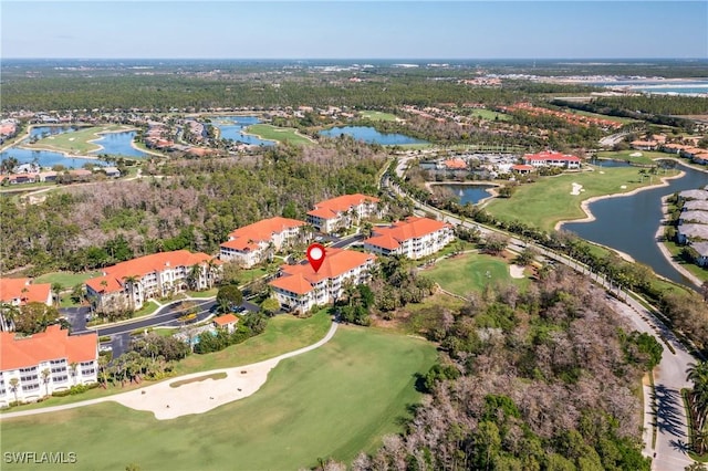 drone / aerial view with golf course view and a water view