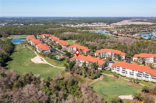 birds eye view of property with view of golf course, a view of trees, and a water view