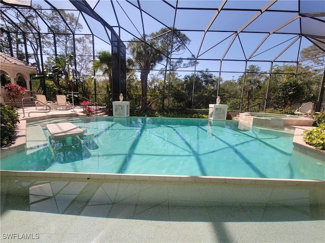 view of swimming pool featuring a patio, a lanai, and a pool with connected hot tub