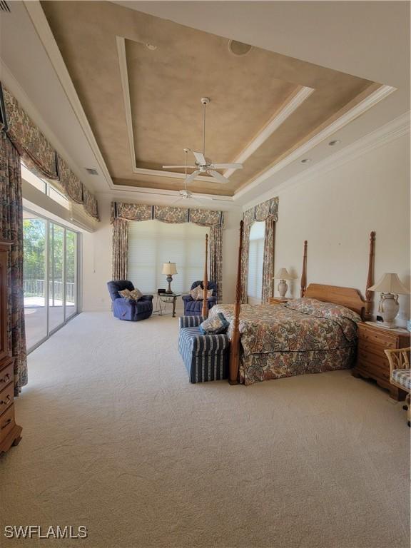 bedroom featuring access to outside, a tray ceiling, carpet, and crown molding