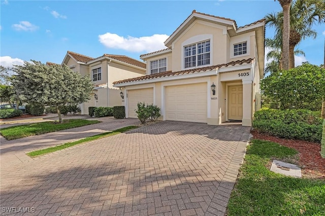 view of front of house featuring decorative driveway, a tiled roof, an attached garage, and stucco siding