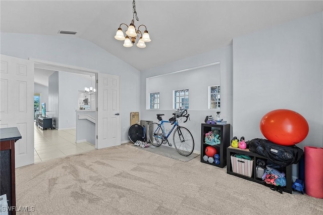 exercise room featuring lofted ceiling, carpet, visible vents, and a notable chandelier