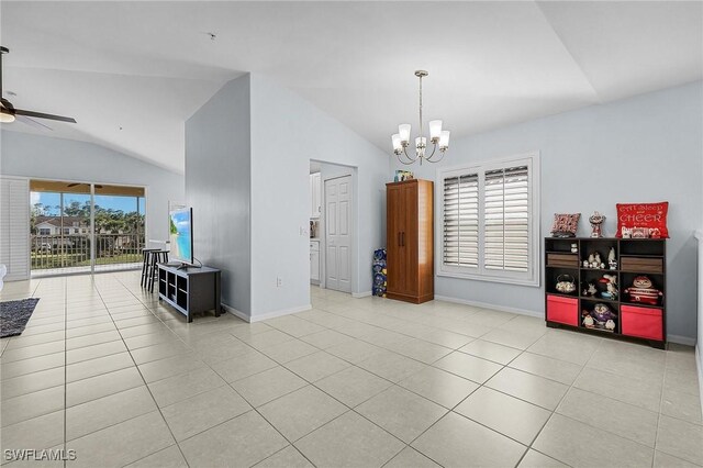 interior space featuring vaulted ceiling, ceiling fan with notable chandelier, and baseboards