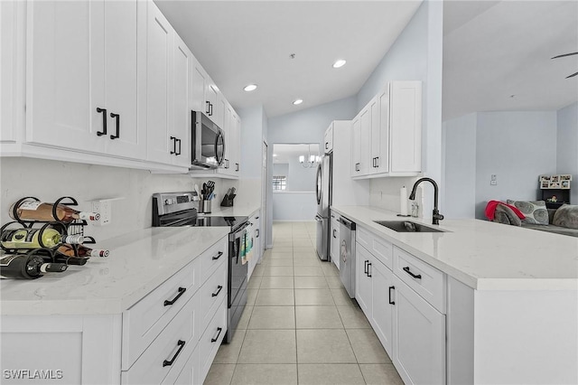 kitchen with light tile patterned floors, white cabinets, stainless steel appliances, a sink, and recessed lighting