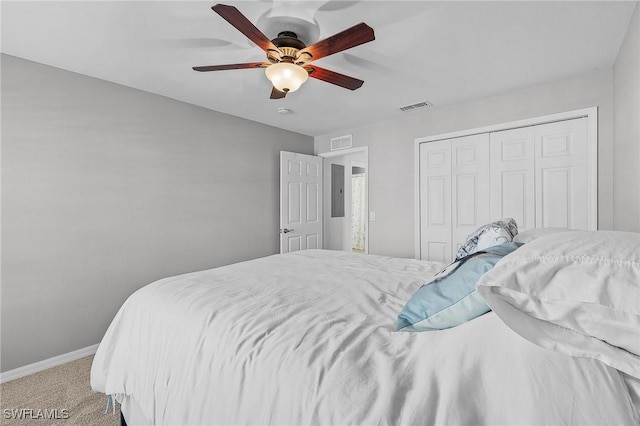 bedroom with baseboards, visible vents, a closet, and light colored carpet