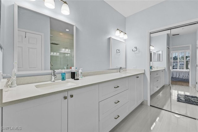 bathroom with double vanity, a stall shower, a sink, and ensuite bath