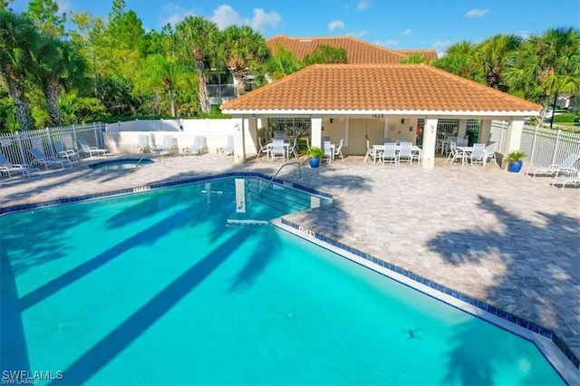 community pool featuring a patio area and fence