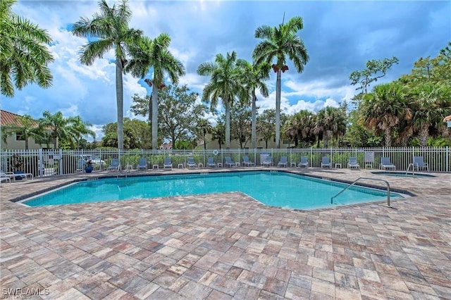 community pool featuring fence and a patio