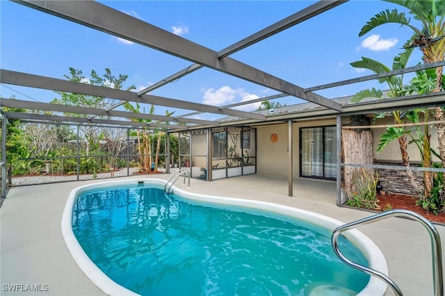 pool with glass enclosure and a patio area