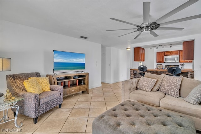 living area featuring light tile patterned floors, visible vents, ceiling fan, track lighting, and baseboards