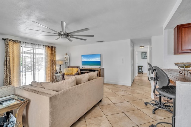 living room with visible vents, a ceiling fan, light tile patterned flooring, a textured ceiling, and baseboards