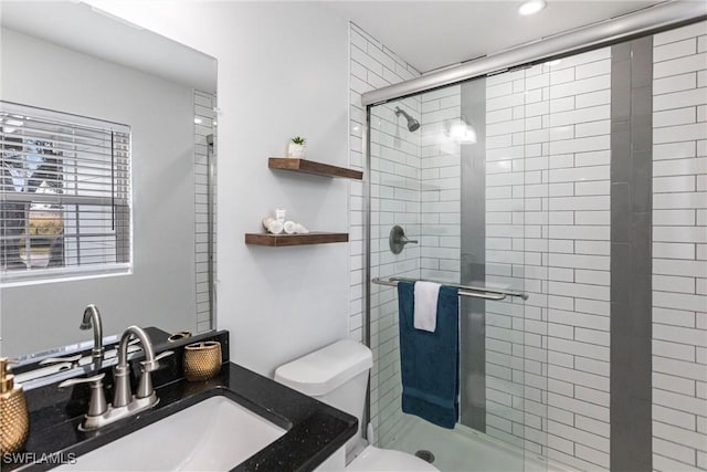 bathroom with sink, toilet, and a shower with door