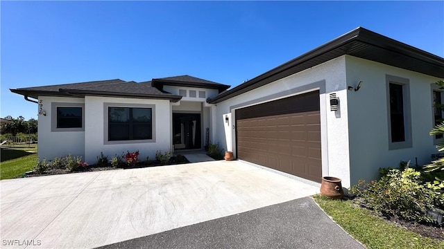 view of front of home featuring a garage, driveway, and stucco siding