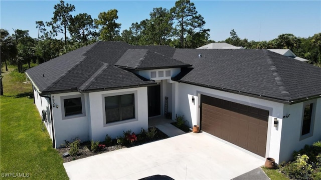 view of front of house with a garage, a shingled roof, concrete driveway, a front yard, and stucco siding