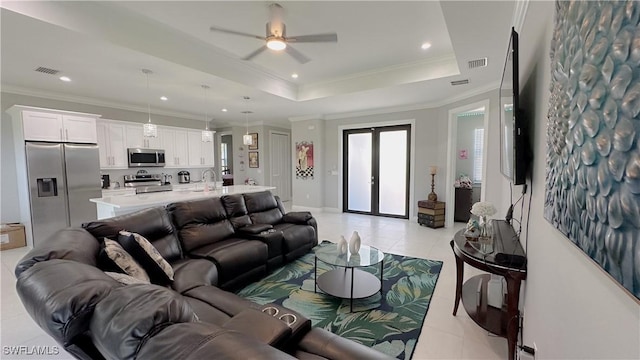 living room with light tile patterned floors, visible vents, a raised ceiling, and french doors