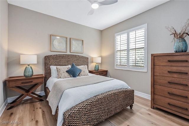 bedroom featuring ceiling fan, light wood finished floors, and baseboards